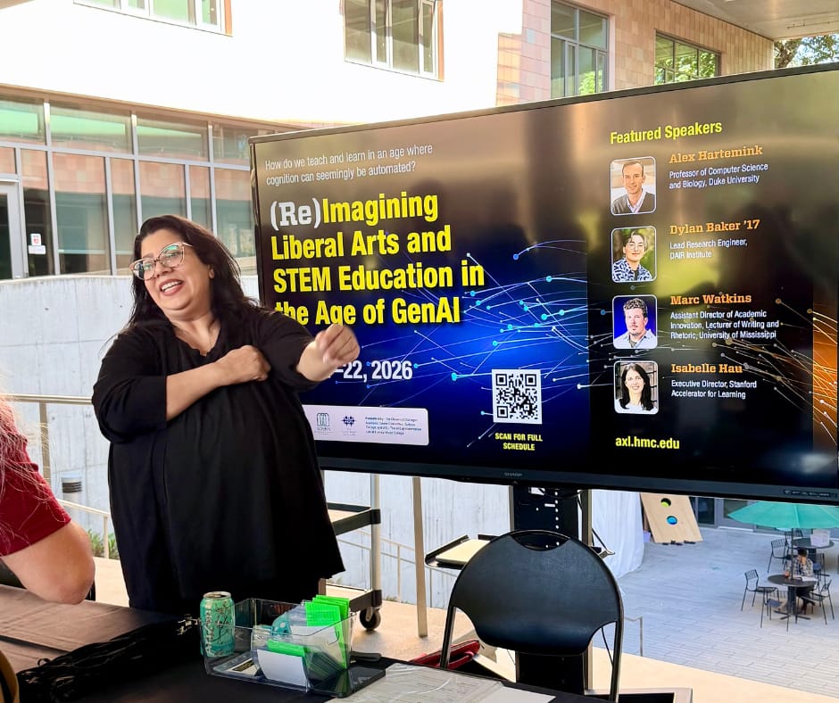 Woman stands in front of a large display with information about the conference
