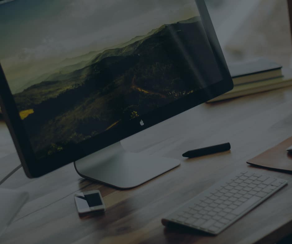 computer keyboard and monitor sitting on a desk