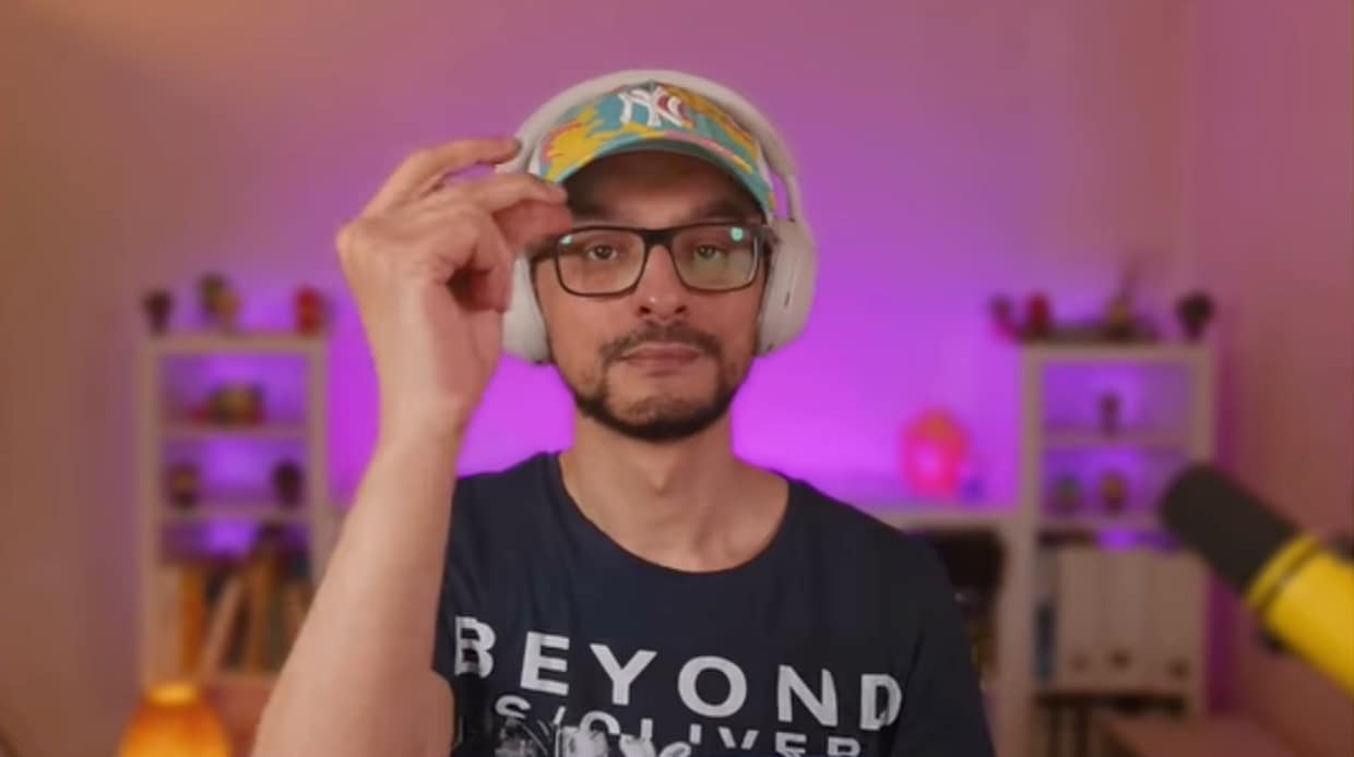 Man snaps his fingers as he adjusts his lighting and other aspects of his online setup