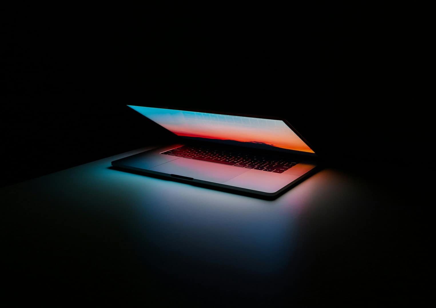 Macbook opening up in a dark room - showing bright colors