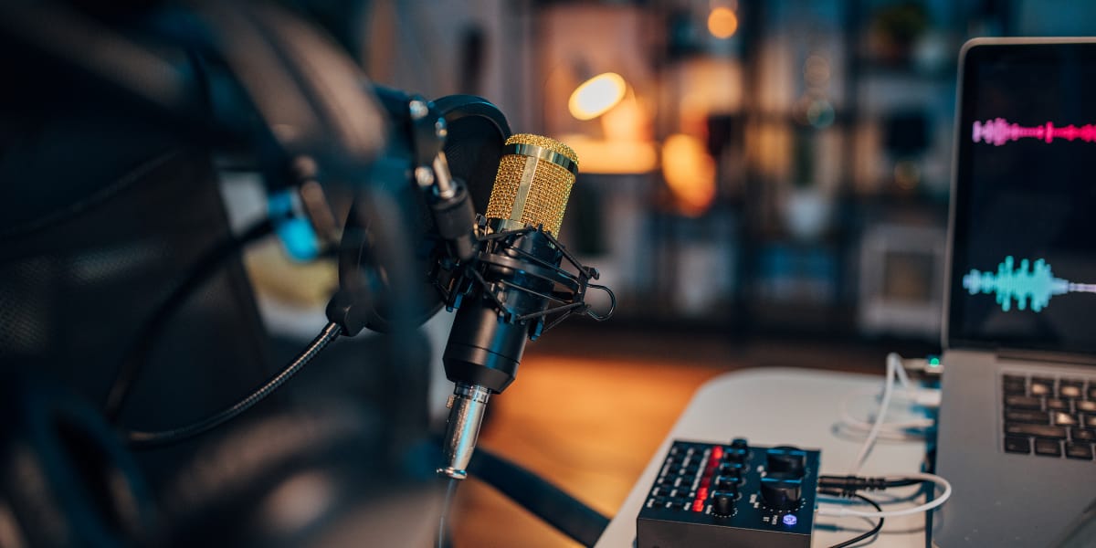 podcast setup with mic and monitor showing pink volume level indicators