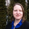 Brown-haired white woman with a vibrant blue shirt on and a black blazer