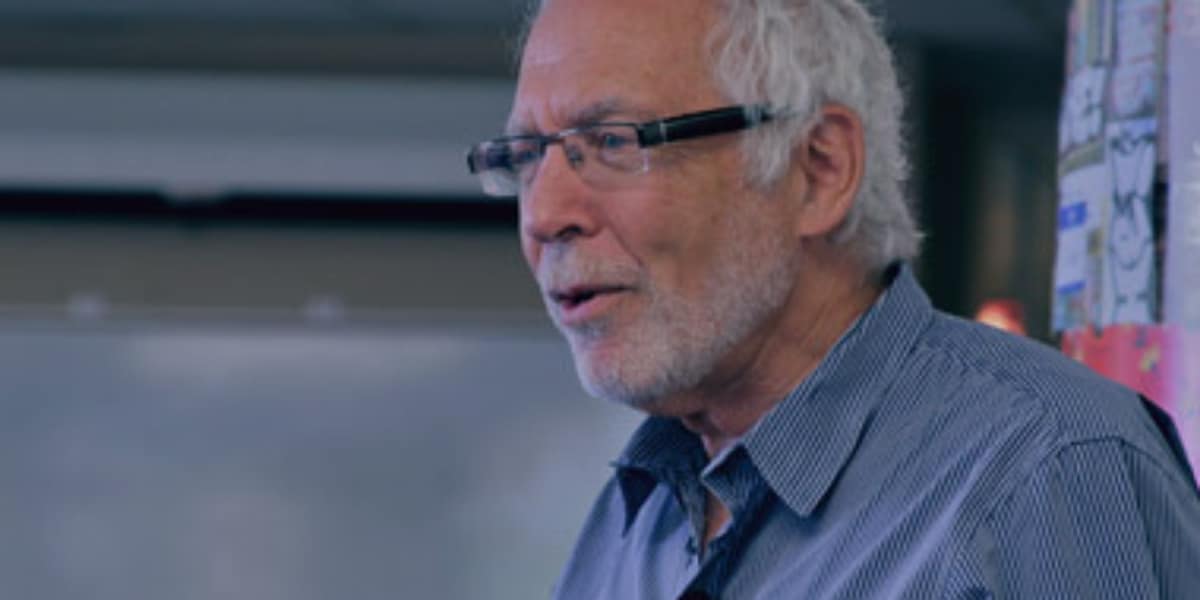 man with glasses presents to an audience
