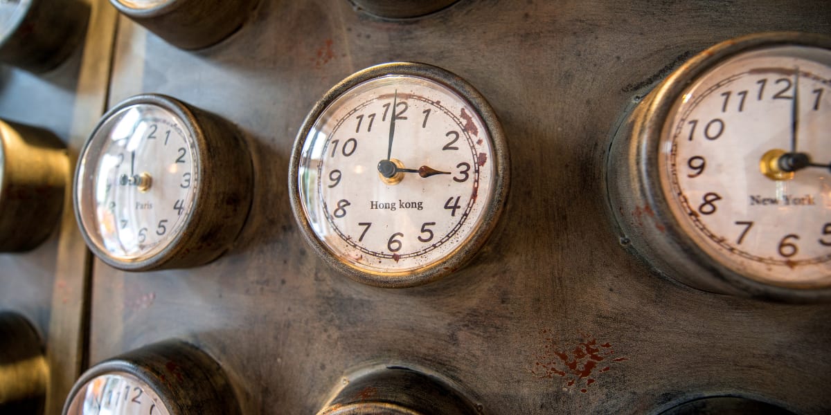 Old fashioned analog clocks show the time in different places in the world