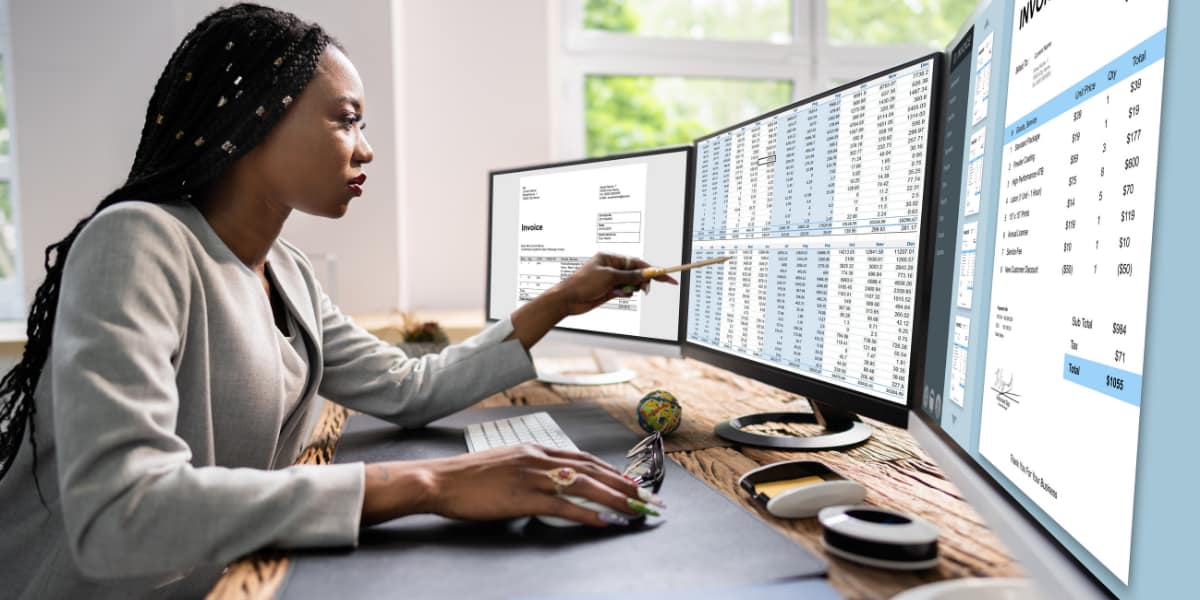 woman uses excel on multiple monitors