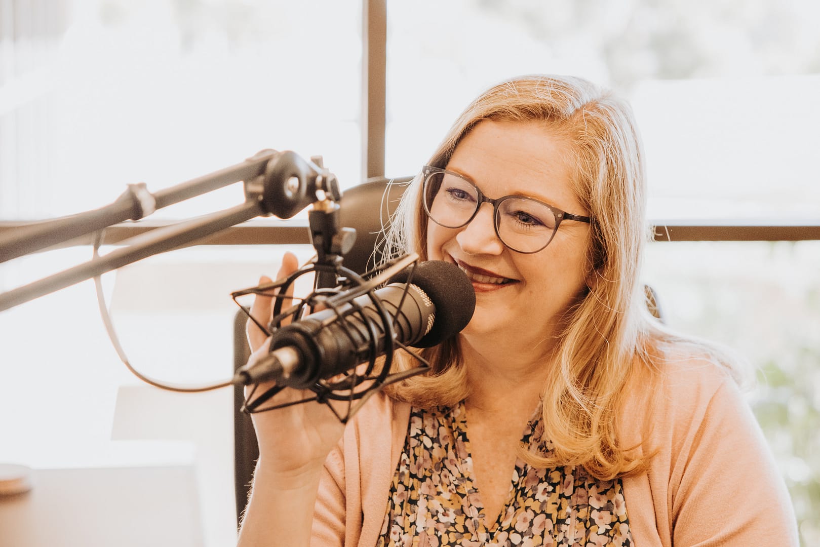 Woman talks into a microphone, smiling