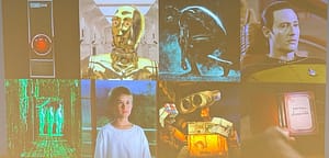 Alex Hartemink presenting from the front of a large lecture hall. His slide is titled "Humans have longed to make intelligent beings in their own image" and shows a collage of film stills