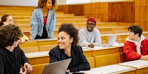 students sit in a university lecture hall and talk together