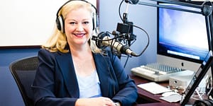 Bonni wears headphones and talks into a podcasting microphone