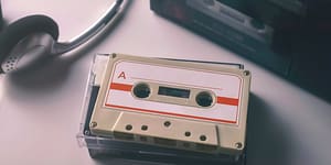 cassette tape sits on a desk with old headphones