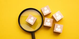 magnifying class with a block with a figure printed on it - four other figures are outside the view of the magnifying class