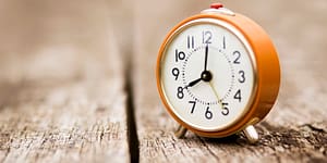 analog clock sits on wooden slats