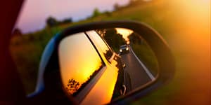 Side view mirror of a car reflecting a sunset