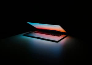 Macbook opening up in a dark room - showing bright colors