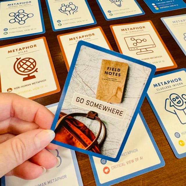 person holding a card that says, "Go Somewhere" with travel related images on it