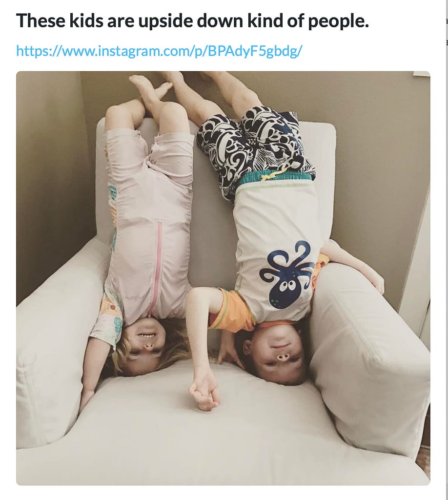 Two kids stand on their heads, upside down in a cushioned swivel chair