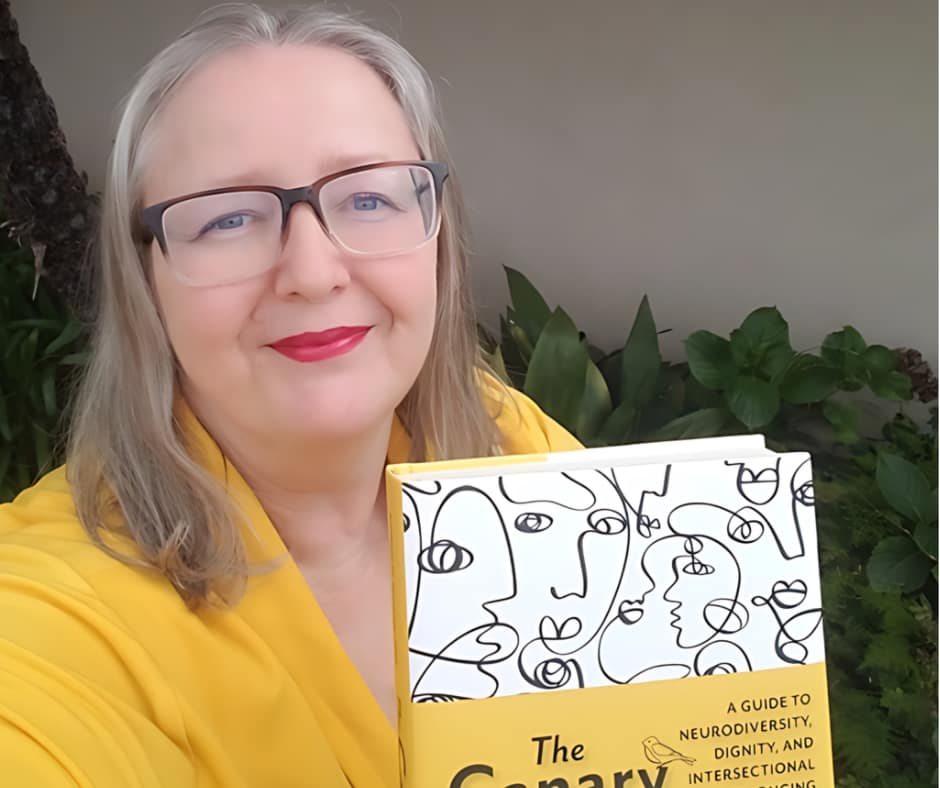 Ludmila holds a copy of her book: The Canary Code