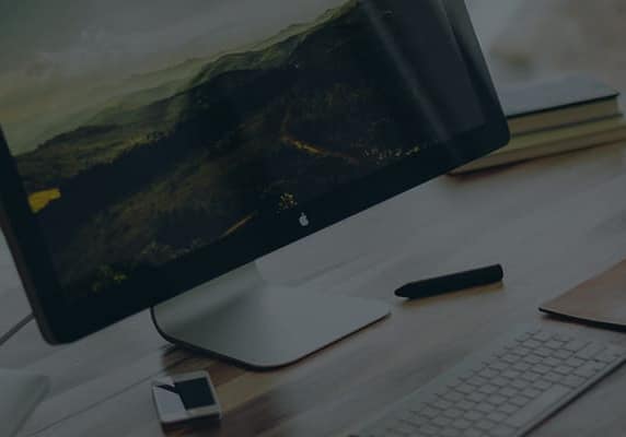 computer keyboard and monitor sitting on a desk